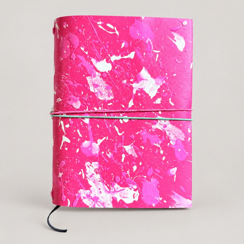 Pink leather journal with white paint splatters